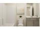 Clean bathroom featuring a tub and shower, a vanity with gray cabinets, and neutral decor at 1011 Red Roses Ave, Durham, NC 27703