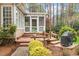 Outdoor back deck with seating, lush landscaping, and wooded views at 105 Fifemoor Ct, Cary, NC 27518