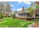 Expansive backyard with a well-manicured lawn, screened porch, and mature trees at 105 Fifemoor Ct, Cary, NC 27518