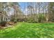 Lush green backyard with mature trees and attractive landscaping at 105 Fifemoor Ct, Cary, NC 27518