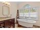 Bright bathroom with a soaking tub, vanity, and natural light from large window at 105 Fifemoor Ct, Cary, NC 27518