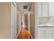 Hallway with beautiful hardwood flooring, and white cabinets with a sink in the background at 105 Fifemoor Ct, Cary, NC 27518