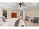 This main bedroom has a tray ceiling, a ceiling fan, and two chairs at 105 Fifemoor Ct, Cary, NC 27518