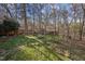 Sloping green backyard with wooded area and some landscaping with natural stone at 109 Boulder Ln, Chapel Hill, NC 27514