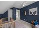 Bedroom featuring blue accent walls, a crib, a cozy chair, and a fun dog portrait on the wall at 109 Boulder Ln, Chapel Hill, NC 27514