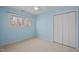 Bedroom with carpet floors, closet, blue accent walls, a ceiling fan, and a large window overlooking the yard at 109 Boulder Ln, Chapel Hill, NC 27514
