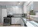Well-lit kitchen with tiled countertops, stainless steel appliances, and a view to the outdoors at 109 Boulder Ln, Chapel Hill, NC 27514