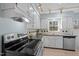 Kitchen showcasing white cabinets, tiled countertops, and modern stainless steel appliances at 109 Boulder Ln, Chapel Hill, NC 27514