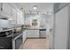 Bright kitchen featuring white cabinets, stainless steel appliances, and tiled countertops at 109 Boulder Ln, Chapel Hill, NC 27514