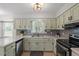 Well-lit kitchen featuring stylish cabinets, marbled countertops, stainless steel appliances, and a gray backsplash at 1107 Edgebrook Dr, Garner, NC 27529