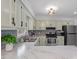 Open kitchen with marbled countertops, stainless appliances, a gray backsplash, and light wooden cabinets at 1107 Edgebrook Dr, Garner, NC 27529