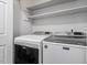 Bright laundry room with modern Maytag washer and dryer set and convenient overhead shelving at 1107 Edgebrook Dr, Garner, NC 27529