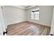 Well-lit bedroom with modern wood-look flooring, neutral paint, and a large window for natural light at 120 Sequoia Dr, Louisburg, NC 27549
