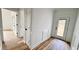 Bright hallway with wood-look floors leads to an exterior door with traditional white wainscoting detail at 120 Sequoia Dr, Louisburg, NC 27549
