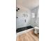 Modern shower featuring white subway tile, sleek glass doors and black fixtures, complemented by black honeycomb tile floor at 120 Sequoia Dr, Louisburg, NC 27549