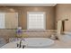 Close up of the bathtub in the bathroom with a tiled surround and a decorative window at 120 Teasel Ct, Clayton, NC 27527