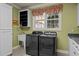 A functional laundry room with modern appliances, a sink, and ample cabinet space at 120 Teasel Ct, Clayton, NC 27527