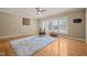 Sunlit living room with hardwood floors, ceiling fan, and large windows with plantation shutters at 120 Teasel Ct, Clayton, NC 27527