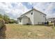 View of a large grassy backyard with garden beds, privacy fence, and the side of the house at 127 S Harrison Place Ln, Fuquay Varina, NC 27526
