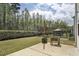 Large backyard with patio, string lights, and a view of the wooded area at 127 S Harrison Place Ln, Fuquay Varina, NC 27526