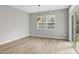 Bright dining area with large windows, hardwood floors, and a modern light fixture at 127 S Harrison Place Ln, Fuquay Varina, NC 27526