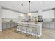 Bright kitchen with white cabinets, granite countertops, a large island with seating, and hardwood floors at 127 S Harrison Place Ln, Fuquay Varina, NC 27526