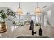 Open-concept kitchen with granite countertops and view to living room, stainless appliances and barstool seating at the island at 127 S Harrison Place Ln, Fuquay Varina, NC 27526