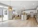 Open floor plan featuring a spacious living room flowing into the modern kitchen with stainless steel appliances at 127 S Harrison Place Ln, Fuquay Varina, NC 27526
