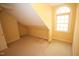 Unfinished attic space showing window and architectural roof details and carpet at 1309 Wakefield Farm Rd, Zebulon, NC 27597