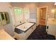 Bathroom featuring a tiled soaking tub, marble countertop, and a decorative wallpaper at 1309 Wakefield Farm Rd, Zebulon, NC 27597