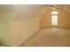 Bright bonus room with arch window, ceiling fan, and neutral carpet provides a flexible space at 1309 Wakefield Farm Rd, Zebulon, NC 27597