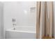 Clean white bathtub with shower, white tile surround, and practical design at 1317 Garner Rd # 101, Raleigh, NC 27610