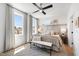 Bright main bedroom featuring an area rug, bench, ceiling fan, and large sunlit windows at 1317 Garner Rd # 101, Raleigh, NC 27610