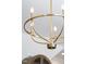 Close-up of a modern gold chandelier adding a touch of elegance to the living room at 1317 Garner Rd # 101, Raleigh, NC 27610