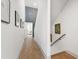Bright hallway featuring wood floors, modern wall decor, and access to multiple rooms at 1317 Garner Rd # 101, Raleigh, NC 27610