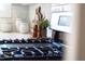 Close-up of stainless cooktop with white tile backsplash, decorative pots and wooden spoons at 1317 Garner Rd # 101, Raleigh, NC 27610