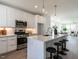 Stylish kitchen with stainless steel appliances, white cabinetry, and a spacious island with seating for three at 1317 Garner Rd # 101, Raleigh, NC 27610