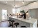 Sleek modern kitchen features white cabinets, quartz countertops, stainless appliances, and island with bar stool seating at 1317 Garner Rd # 101, Raleigh, NC 27610