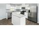 Bright kitchen features white cabinets, stainless steel appliances, a kitchen island, and a large window for natural light at 156 Sunny Acres Rd, Garner, NC 27603
