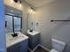 New bathroom featuring double sinks with grey vanities, updated lighting, and a shower at 163 Grace Pond Ave, Benson, NC 27504