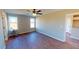 Large bedroom features a ceiling fan, hardwood flooring, and natural light from the windows at 163 Grace Pond Ave, Benson, NC 27504