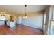 Bright dining area with hardwood floors, view into kitchen with bar top, and modern chandelier at 163 Grace Pond Ave, Benson, NC 27504