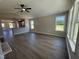 Open-concept living room with sleek hard surface floors, a ceiling fan, and ample natural light from large windows at 163 Grace Pond Ave, Benson, NC 27504