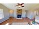 Bright living room featuring a stone fireplace, ceiling fan, and hardwood floors at 163 Grace Pond Ave, Benson, NC 27504