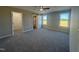 Spacious main bedroom with plush carpet, natural light from two windows, and a sliding barn door at 163 Grace Pond Ave, Benson, NC 27504