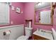 Cozy pink half-bathroom with white wainscotting and a decorative mirror at 1800 Tee Dee St, Raleigh, NC 27610