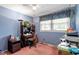 This bedroom features blue walls, a ceiling fan, and a sunny window at 1800 Tee Dee St, Raleigh, NC 27610
