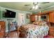 Cozy main bedroom featuring wood floors, a ceiling fan, and an ensuite bathroom at 1800 Tee Dee St, Raleigh, NC 27610