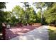 Private backyard with a deck, chairs, and a concrete path surrounded by lush greenery, providing a serene outdoor space at 1905 Cedar Dam Ln, Wendell, NC 27591