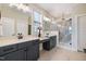 Well-lit bathroom featuring double vanity and a walk-in shower with decorative tiling at 1905 Cedar Dam Ln, Wendell, NC 27591